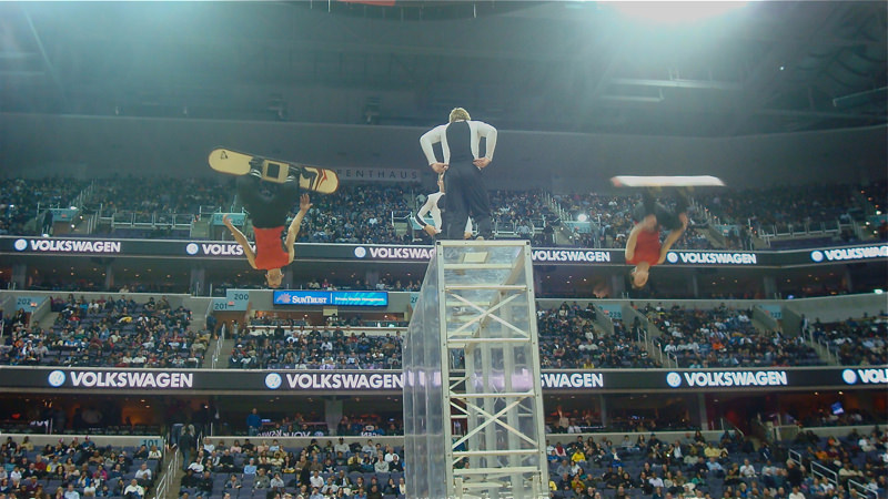 two athletes in the air performing in an indoor stadium