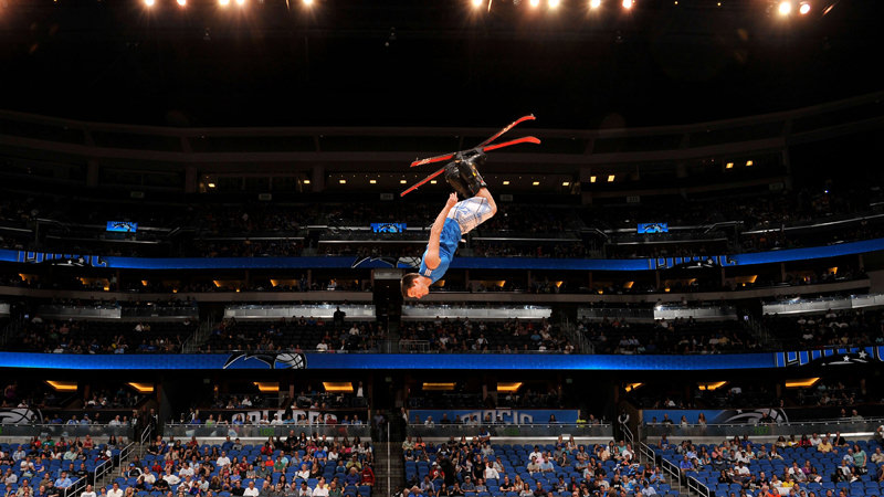 athlete performing in the air in the transparent wall show with two trampolines